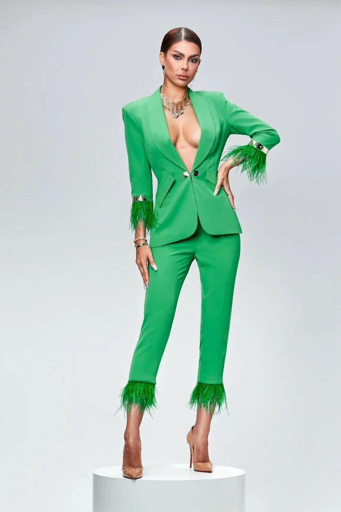 Completo tailleur verde Bby accessoriato con piume decorative e accessori dorati