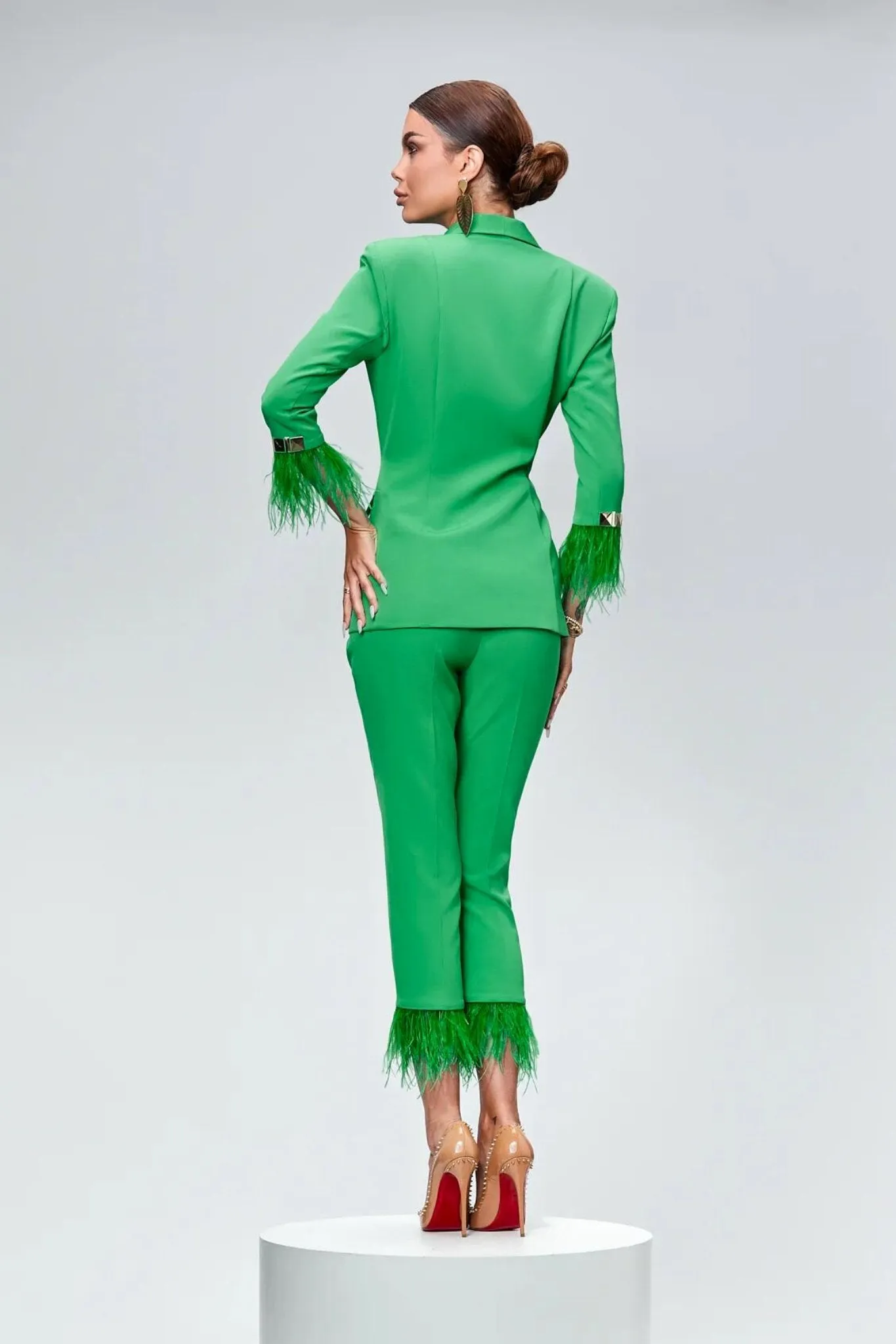 Completo tailleur verde Bby accessoriato con piume decorative e accessori dorati